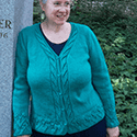 A long-sleeved v-necked cardigan with organic lace patterning around cuffs and hem and down the button band 