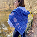 Lunar Love triangular shawl with moon phase colorwork motifs and tassels on the three corners