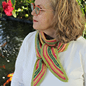 Curved-edge long scarf in textured stripes of bright saturated orange and various greens