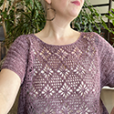 Crocheted short-sleeved pullover with solid sides and delightful openwork floral motif in front and back
