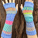Long fingerless mitts that use a single background color and scraps to show off sections of different wavy colors