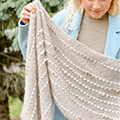 Rectangular shawl with button-decorated end and ripply stripes