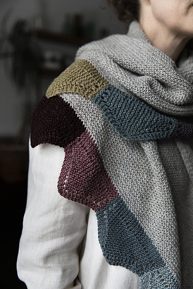 A page from 52 Weeks of Scrap Yarn, featuring a shawl worked in garter stitch with the edging made of reds and teals and resembling bunting.