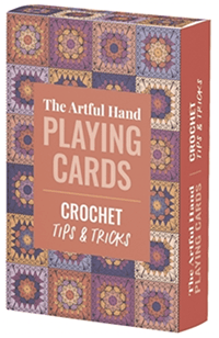 The box that The Artful Hand Playing Cards come in with the title in a pinkish rectangle and a background of various granny squares.