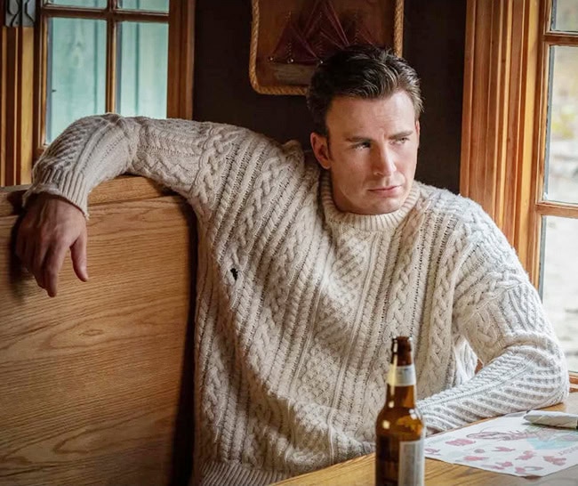 Chris Evans in a scene from Knives Out where he's wearing a white cable-knit sweater.